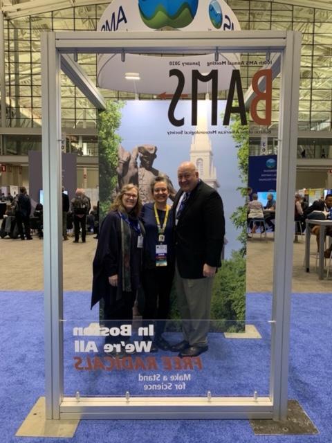 Meteorology alumni posing in front of a BAMS sign at AMS Boston 2020