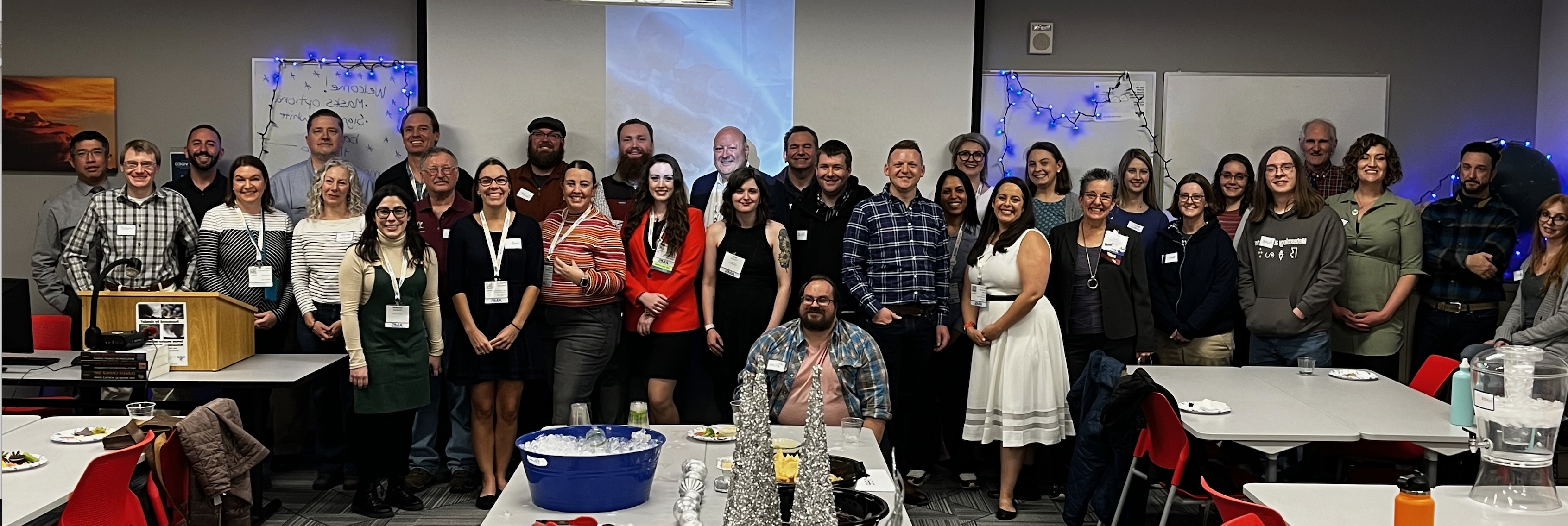 Photo of about 35 people posing at a meteorology alumni party in the meteorology classroom